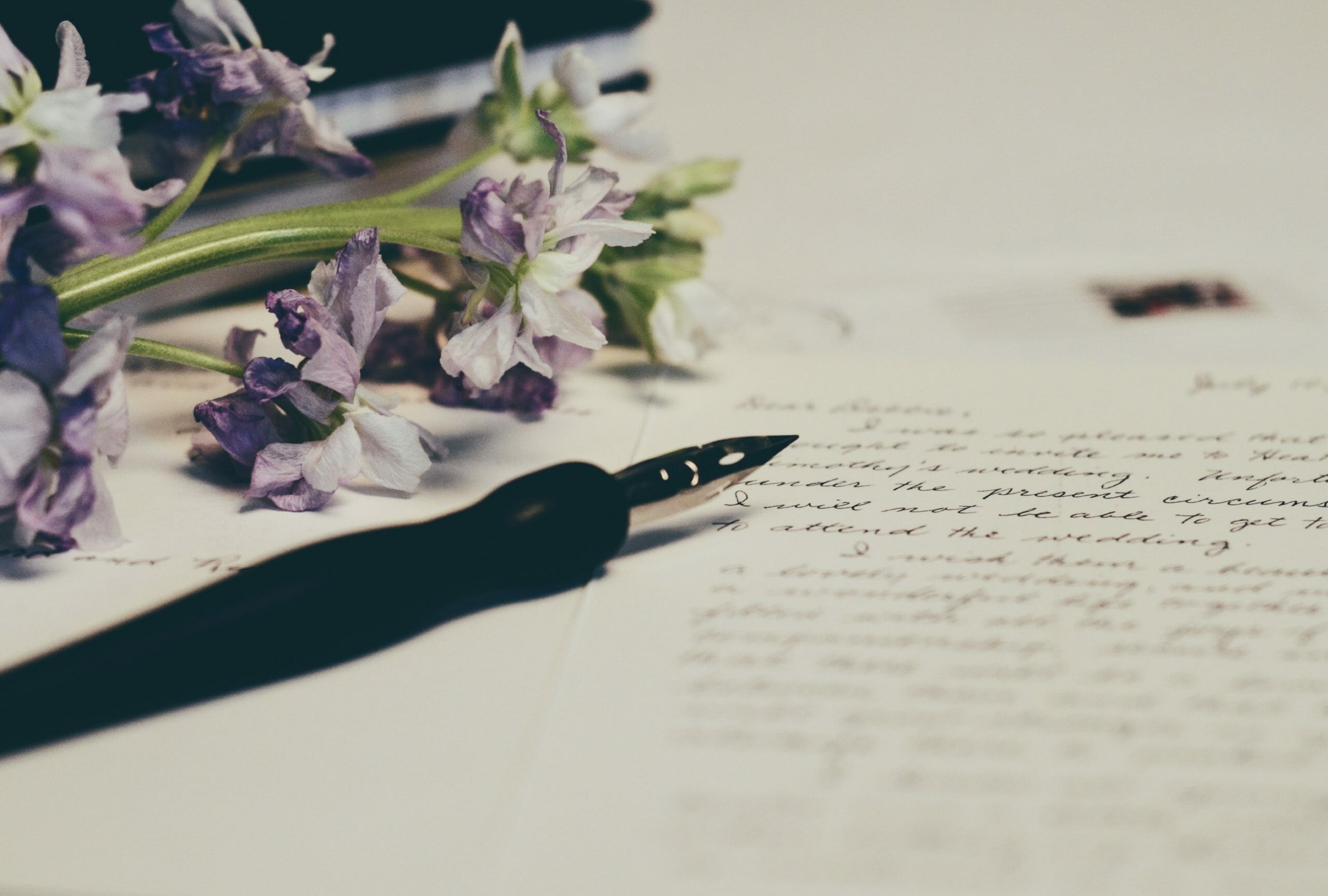 Fountain pen on written text and lilacs - Something Simple First Legal Design Blog