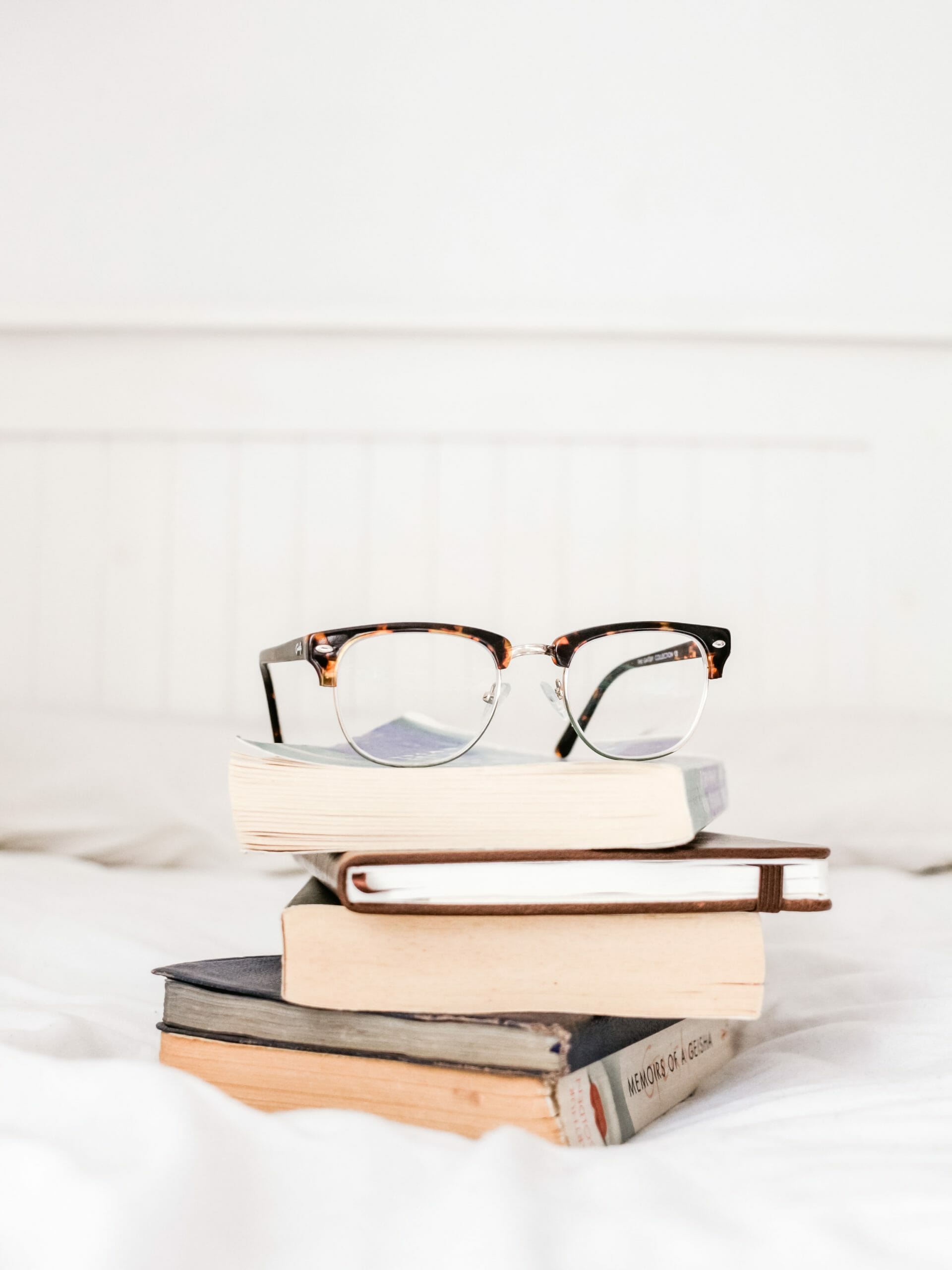 Pair of glasses on top of book pile - Legal Design Blog Something Simple First